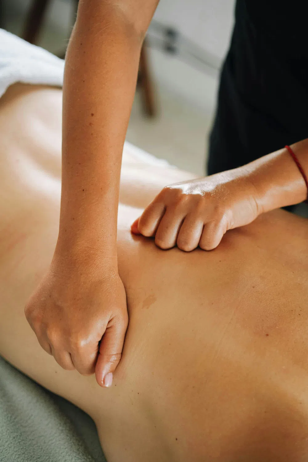 Therapist's hands working along a client's back during a massage